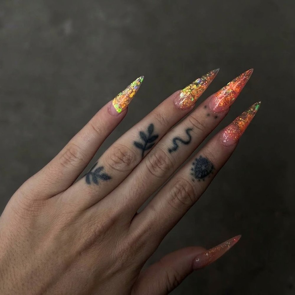Uñas esculpidas stiletto largas con glitter naranja y dorado tornasolado