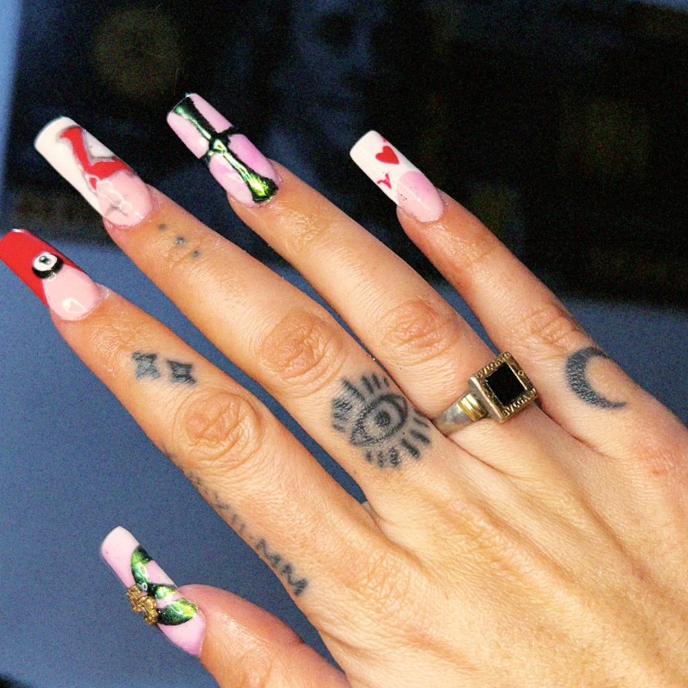 Uñas coffin largas con nail art en rojo, verde y blanco, con apliques